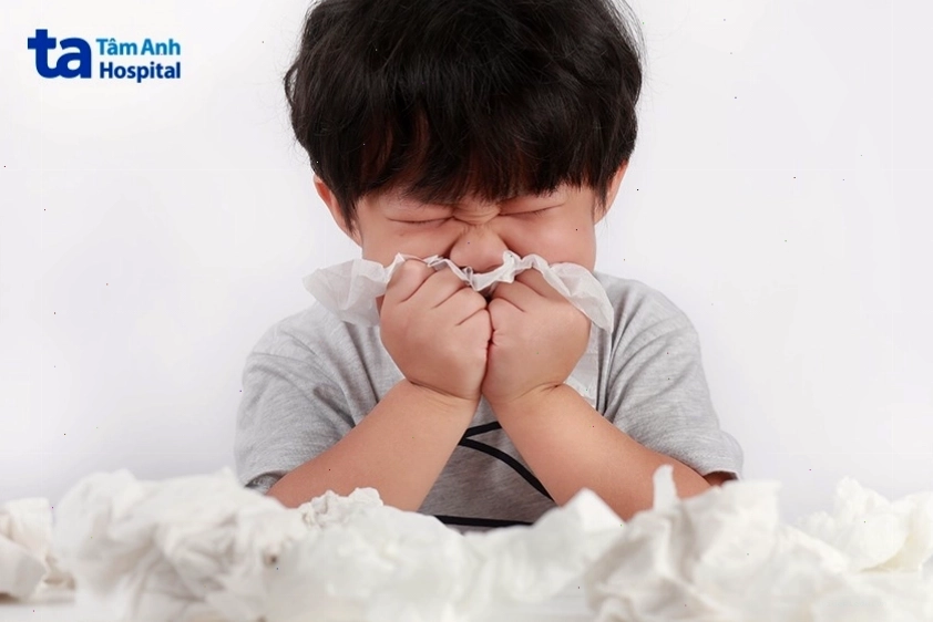 Trẻ đang được người lớn xịt mũi bằng dung dịch nước muối sinh lý